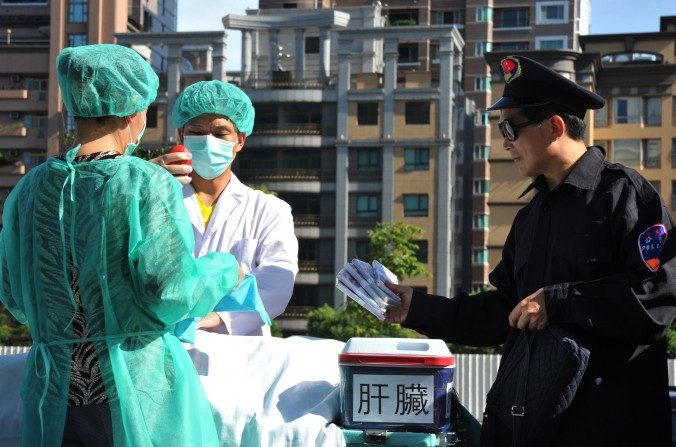 Des pratiquants de Falun Gong simulent une scène de vol d'organes humains à revendre, lors d'une manifestation à Taipei, le 20 juillet 2014. (Mandy Cheng/AFP/Getty Images)
