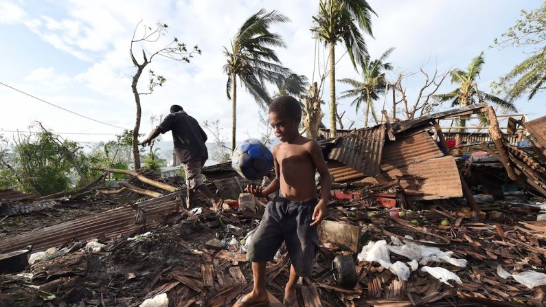 Samuel joue au ballon dans les décombres de la maison familiale après le passage du cyclone Pam qui a frappé Vanuatu à la mi-mars 2015. (Dave Hunt-Pool/Getty Images)