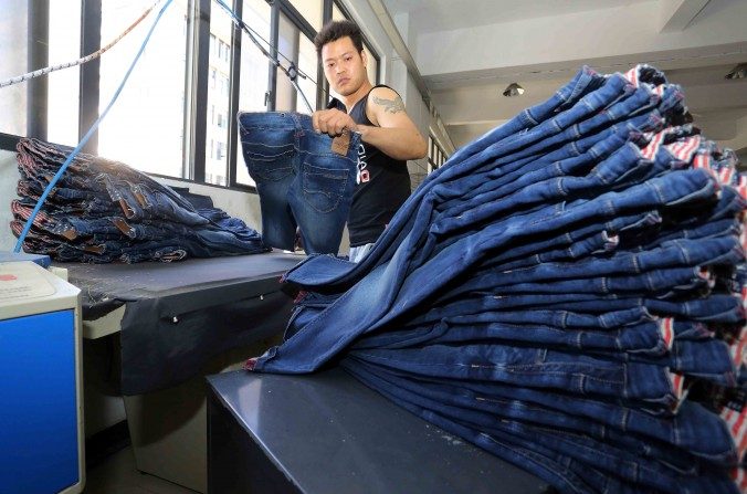 Le 12 mai 2015 : un ouvrier chinois au travail, dans une usine de fabrication de jeans à Shishi, province de Fujian dans l'est chinois. (STR/AFP/Getty Images)