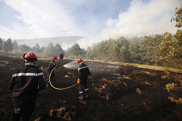Les pompiers travaillent à éteindre un incendie de forêt dans la région méridionale française de Saint-Vallier-de-Thiey, au nord de la ville de Nice, le 29 juillet, 2015.  (VALERY HACHE / AFP / Getty images)