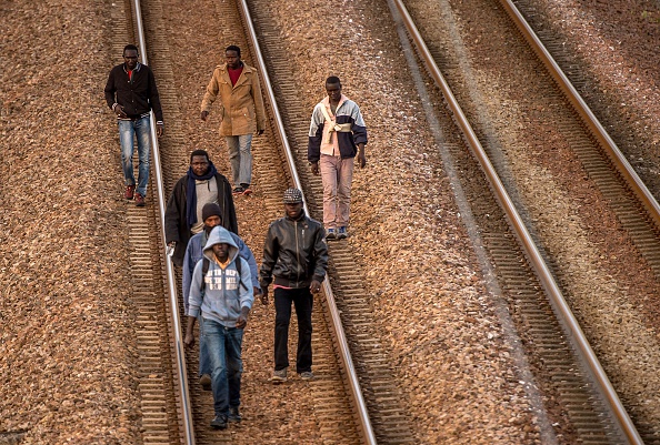 Des migrants marchent sur la voie ferrée de l'Eurostar près de Calais (PHILIPPE HUGUEN/AFP/Getty Images)