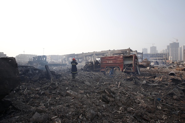 Un pompier se tient au milieu du site des explosions, à Tianjin en Chine le 15 août 2015. (STR/AFP/Getty Images)
