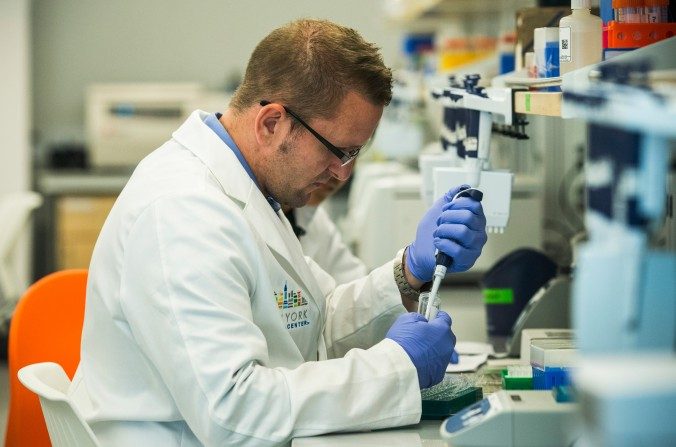 Des techniciens de recherche préparent des échantillons d'ADN à être séquencés dans le laboratoire de production du New York Genome Center le 19 septembre 2013 à New York. (Andrew Burton / Getty Images)
