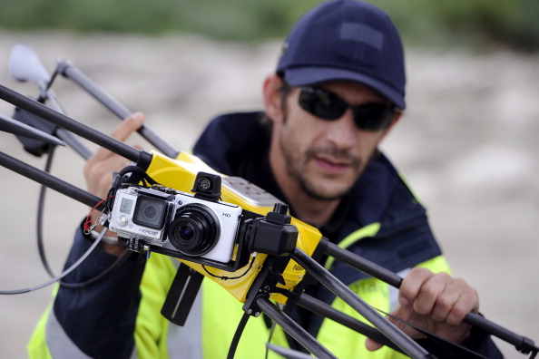 Un technicien de la SNCF montre un drone de surveillance équipé de caméras le 5 novembre 2013 2013 près du viaduc de Roquemaure à Orange, lors d'une opération expérimentale de surveillance d’œuvres d'art. (BORIS HORVAT / AFP / Getty Images)