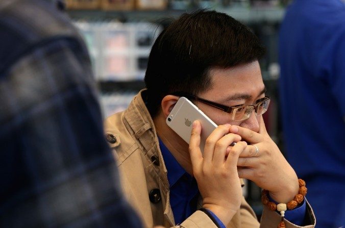 Un homme chinois répond au téléphone sur son nouvel iPhone 6 Plus à l'intérieur d'un magasin Apple le 17 octobre, 2014 à Pékin en Chine. Apple a commencé à commercialiser les smartphones iPhone6 et iPhone6 Plus en Chine continentale le 28 août (Feng Li / Getty Images)
