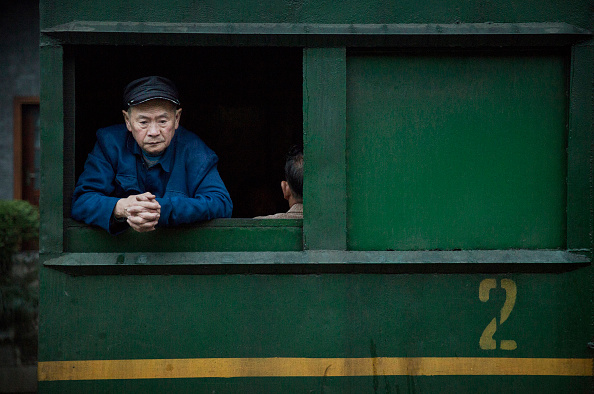 Un villageois attend le départ de son train pour la ville minière de Bgou, au Sichuan. (Kevin Frayer/Getty Images)
