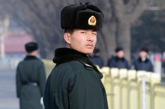 Un policier paramilitaire chinois garde un œil sur les visiteurs du square Tiananmen à Beijing, le 27 janvier 2014. Les autorités ont récemment condamnés près de 200 internautes pour s'être récemment exprimés en ligne. (Goh Chai Hin/AFP/Getty Images)