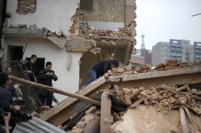 Huang Sufang (C) a réagi pour tenter de protéger sa maison des travailleurs qui ont reçu l’ordre de la démolir dans le village de Yangji, province du Guangdong, au sud de la Chine le 21 mars 2012. (STR / AFP / Getty Images)
