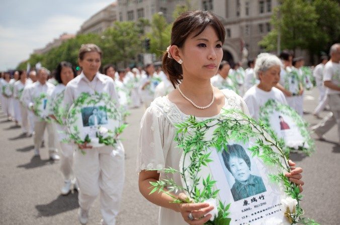 Les pratiquants de Falun Gong portent des photos des victimes de la persécution lors d'un défilé à Washington, le 18 juillet 2011. (Epoch Times)