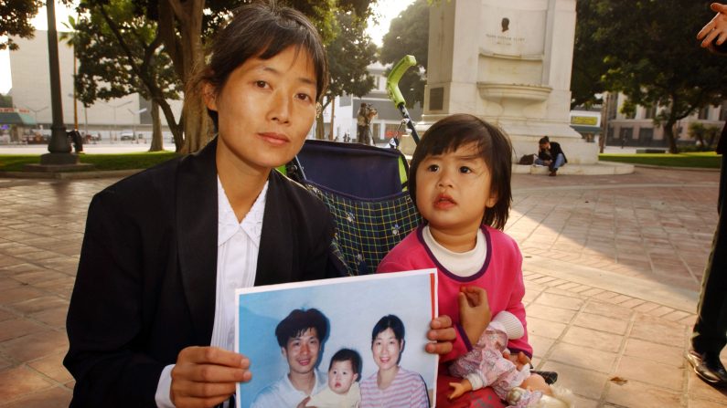  Zhizhen Dai et sa fille, Fadu Chen, tenant un portrait de famille. Le mari de Zhizhen, Cheng Yong Chen, a été condamné à mort pour avoir pratiqué les exercices du Falun Gong. La soeur de Cheng a ensuite été envoyée dans un camp de travaux forcé pour avoir dénoncé la mort de son frère en public. Zhizhen Dai et sa fille ont depuis émigré en Australie.  (David McNew/Getty Images)