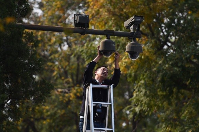 Un technicien ajuste des caméras de sécurité aux abords de la place Tiananmen à Pékin le 30 septembre 2014. (Greg Baker / AFP / Getty Images)