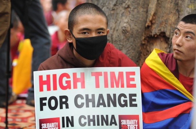 Un moine tibétain tient une pancarte lors d’une manifestation à New Delhi, le 31 janvier 2013. Le régime chinois a déployé un nouveau système de sécurité, qui rendra plus difficile les évasions des Tibétains vers le Népal. (Raveendran/AFP/Getty Images)