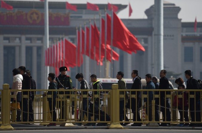 À Beijing, ce 2 Mars 2015, des visiteurs en rang se tiennent devant la place Tiananmen, à côté du Palais de l'Assemblée du Peuple, le lieu des pour réunions de l'Assemblée législative Chinoise. (GREG BAKER/AFP/Getty Images)