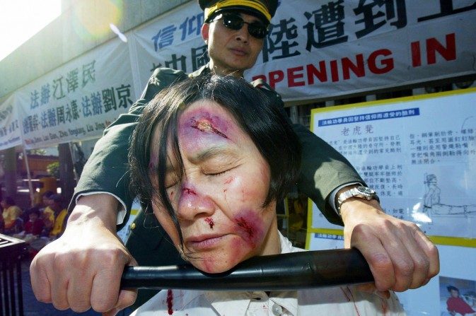 Reconstitution d’une scène de torture d’une pratiquante de Falun Gong en Chine (Mike Clarke/AFP/Getty Images)