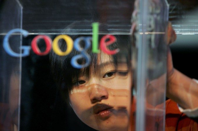 Une femme nettoyant la vitrine derrière laquelle apparaît l'inscription de l'entreprise multinationale Google, implantée à Pékin en 2006. (Guang Niu/Getty Images)