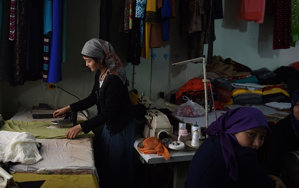 Des femmes ouïghoures travaillent dans un atelier à Hotan dans la région du Xinjiang à l’ouest de la Chine. Les autorités chinoises utilisent les attentats de Paris pour justifier leur répression. (GREG BAKER/AFP/Getty Images)