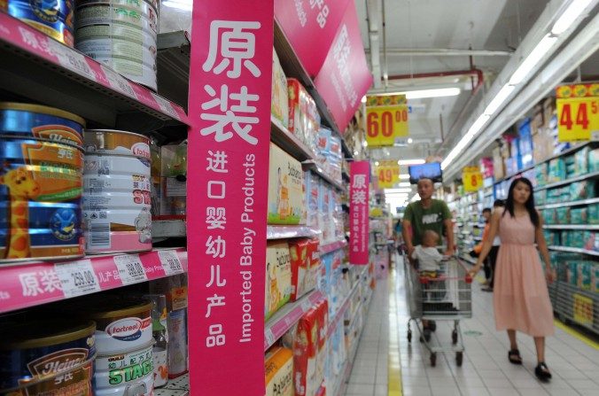 Une famille cherche du lait en poudre dans la section de produits pour bébé importés d'un supermarché à Pékin, le 4 août 2013. (STR / AFP / Getty Images)