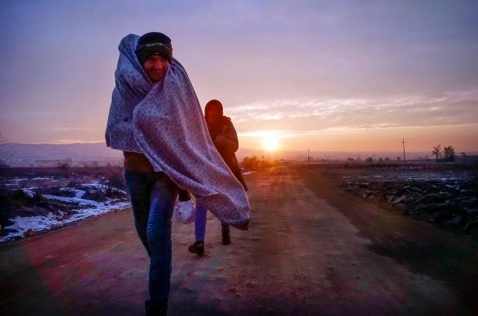 Des migrants tentent de se réchauffer alors qu'ils traversent la frontière séparant la Macédoine de la Serbie, à des températures en dessous de zéro degrés. Cette photographie a été prise à Miratovac, en Serbie, au petit matin du 24 janvier 2016. (Milos Bicanski/Getty Images)