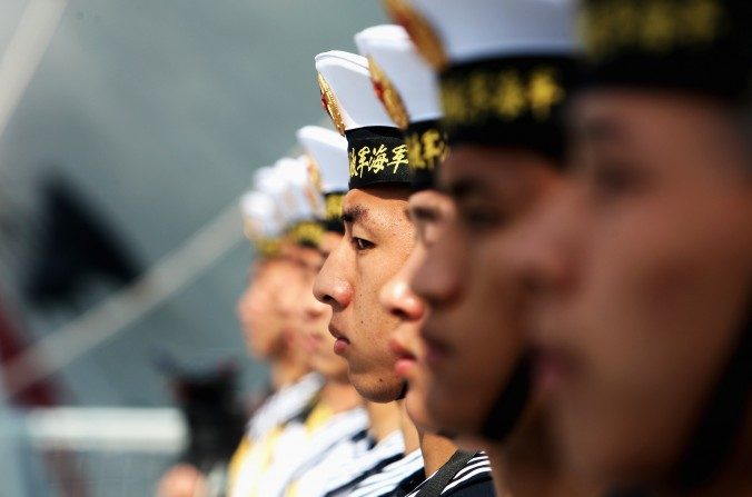 Des militaires de la marine de l’Armée populaire de libération du régime chinois montent la garde sur un cuirassé dans le port de Qingdao, province du Shandong, le 22 avril 2009. Le régime chinois pourrait bientôt construire sa première base militaire à l'étranger .(Guang Niu/Getty Images)