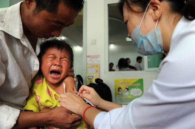 Un garçonnet chinois hurle de douleur alors qu’on lui inocule un vaccin contre la rougeole dans la province orientale d’Anhui, le 11 septembre 2010. La police a mis fin à un trafic illégal de vaccins infectés dans la province du Shandong. (STR/AFP/Getty Images)
