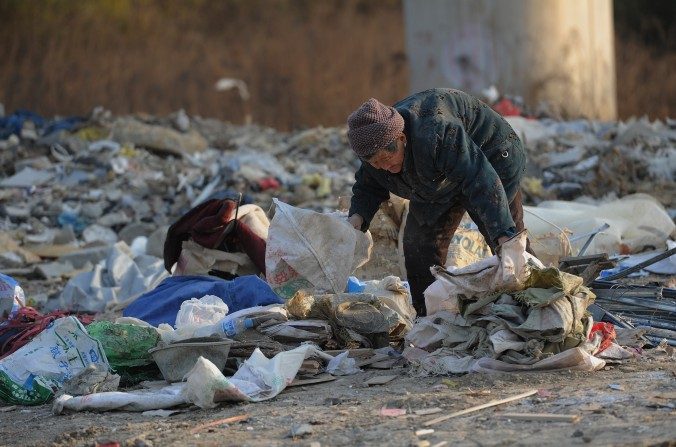 Un homme âgé ramasse des déchets de construction dans un dépotoir de Hefei, province d'Anhui, le 9 décembre 2012. La police a tabassé deux hommes âgés fouillant les poubelles, sous prétexte qu'ils ont enfreint la circulation dans la province du Henan. (STR / AFP / Getty Images)