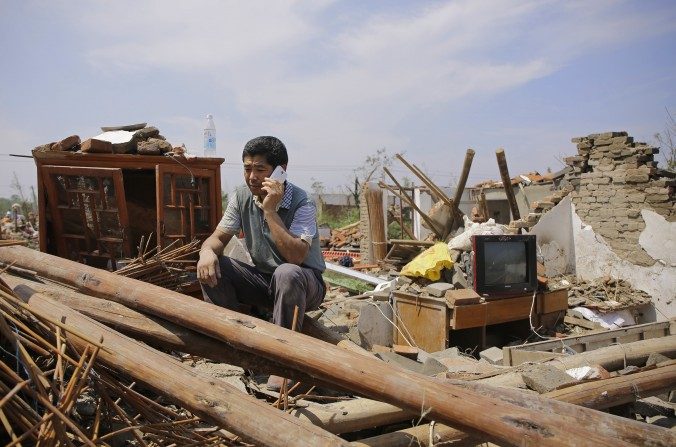 Un villageois chinois devant ce qu’il reste d’une maison du village de Danping, dans la cité de Yancheng, province de Jiangsu. Au total, 99 personnes sont mortes après plusieurs tempêtes conséquentes dans plusieurs villes de Jiangsu, le 23 juin 2016. Environ 1 000 blessés ont été recensés. (Wang He/Getty Images)