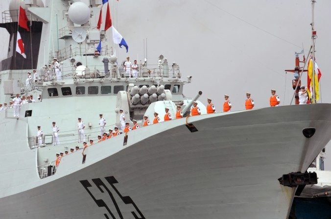 Des marins de la marine de l’Armée populaire de libération (APL) alignés sur le pont d'un navire de guerre chinois dans le port international de Manille, le 13 avril 2010. La Chine a récemment envoyé trois navires de guerre en Tanzanie pour soi-disant discuter des opérations anti-piraterie. (Ted Aljibe / AFP / Getty Images)
