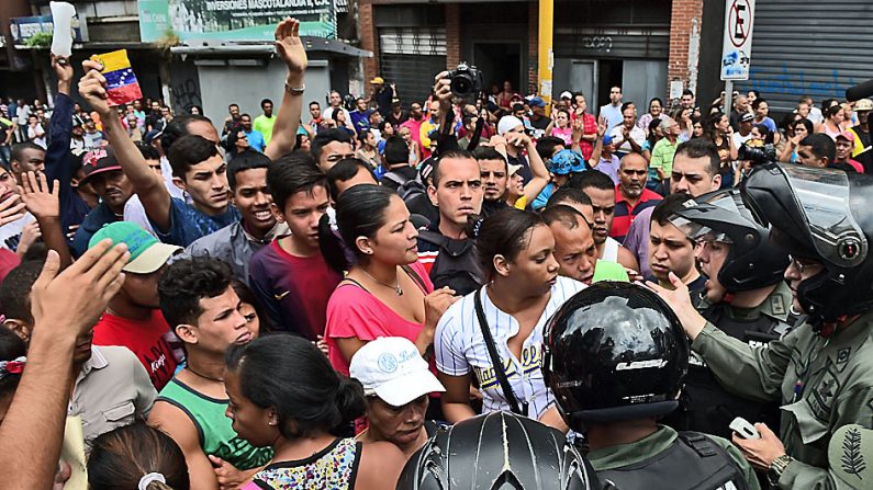 People argue with members of the National Guard as they try to line in front of a supermarket in Caracas on June 2, 2016.  
Venezuela's opposition learns Thursday whether authorities will let them proceed with efforts to call a referendum on removing President Nicolas Maduro, whom they blame for the country's fall from booming oil giant to basket case. The economy is meanwhile forecast to contract eight percent this year and the International Monetary Fund predicts inflation will hit 700 percent. / AFP / RONALDO SCHEMIDT        (Photo credit should read RONALDO SCHEMIDT/AFP/Getty Images)