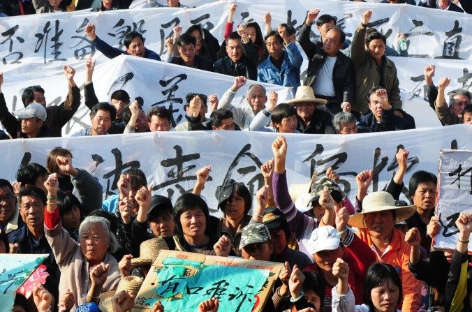 Les villageois de Wukan (un village de pêcheurs dans la province méridionale du Guangdong) tenant des banderoles et des pancartes lors d'une manifestation. Ils exigent que le gouvernement prenne des mesures contre la confiscation illégale de terres et la mort en détention d'un dirigeant local, le 19 décembre 2011. (STR / AFP / Getty Images)
