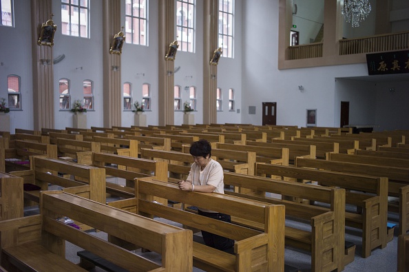 Une femme priant dans une église catholique à Tianjin, le 7 juin 2015. De nombreuses églises dans les provinces chinoises ont été transformées en des centres culturels. (Fred Dufour/AFP/Getty Images) 