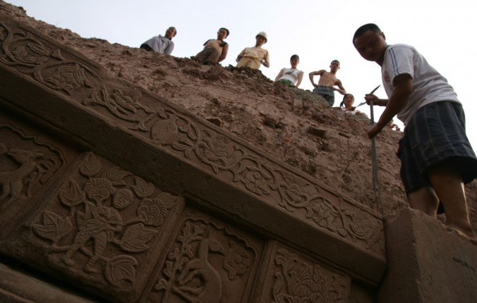 Des ouvriers travaillant à l'excavation d'une tombe, sur un site de construction dans le district de Yubei. Chongqing, le 28 août 2006. (China Photos/Getty Images)