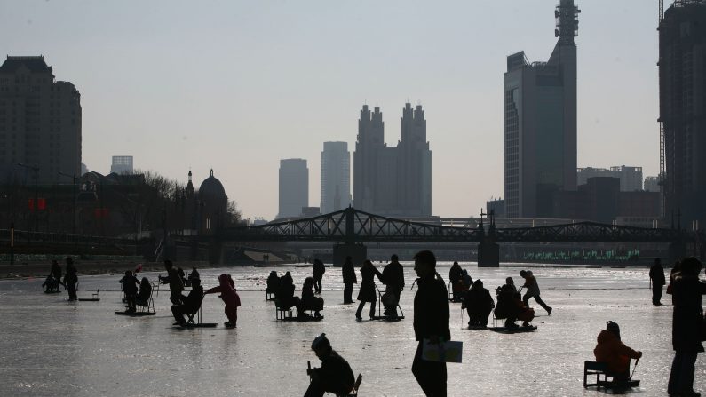 Des personnes jouant sur le fleuve Hai He le 26 janvier 2009 à Tianjin, Chine. (China Photos/Getty Images) 
