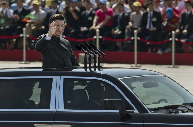 Le chef du Parti communiste chinois Xi Jinping salue depuis une décapotable les soldats et les autres participants assemblés en face de la place Tiananmen et de la Cité Interdite lors du défilé militaire à Pékin, le 3 septembre 2015. (Kevin Frayer / Getty Images)