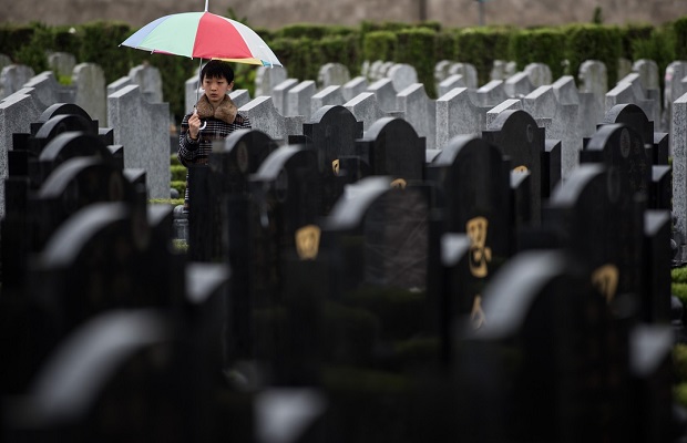 Un garçon se tient entre des tombes lors du festival annuel de «  Qingming », ou le Jour de nettoyage des tombes, dans un cimetière public le 6 avril 2015.  (Johannes Eisele/AFP/Getty Images) 