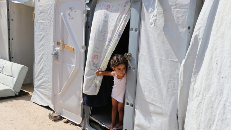 Une fillette syrienne regarde par l’entrée de la tente de sa famille dans le camp de Souda, à Chios. (John Psaropoulos/IRIN)