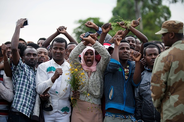 Les habitants de Bishoftu en Étiopie croisent leurs poignets au-dessus de leurs têtes comme symbole de protestation contre le gouvernement, le 2 octobre 2016. Plusieurs personnes ont été tuées après que la police ait tiré des gaz lacrymogènes contre les manifestants lors d'un festival religieux, selon un photographe de l'AFP sur les lieux. (ZACHARIAS ABUBEKER / AFP / Getty Images)