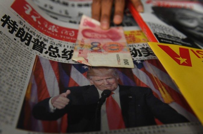 Un billet de 100 yuans mis sur un journal avec une photo de Donald Trump dans un kiosque à journaux à Pékin, le 10 novembre 2016. Trump a tenu des propos très critiques sur le commerce - et sa politique pourrait effectivement aider la Chine. (Greg Baker / AFP / Getty Images)

