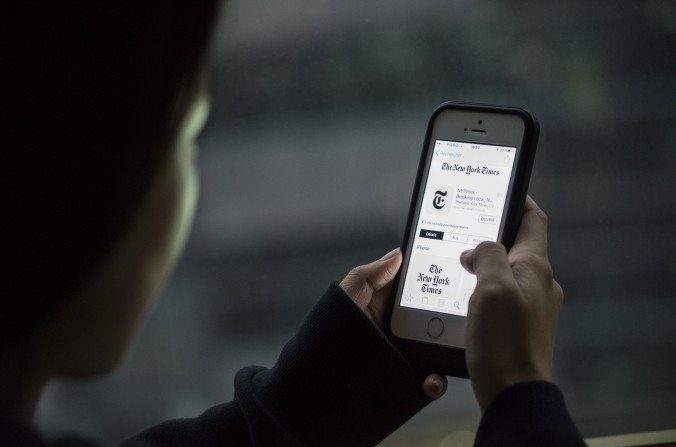 Une internaute chinoise montre l’application du New York Times sur son iPhone, le 5 janvier 2017, à Pékin. (Fred Dufour / AFP / Getty Images)
