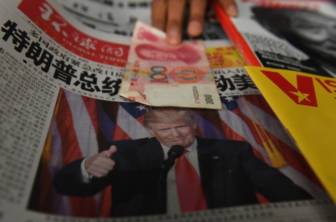 Un billet de 100 yuans mis sur un journal avec une photo de Donald Trump dans un kiosque à journaux à Pékin, le 10 novembre 2016. (Greg Baker / AFP / Getty Images)