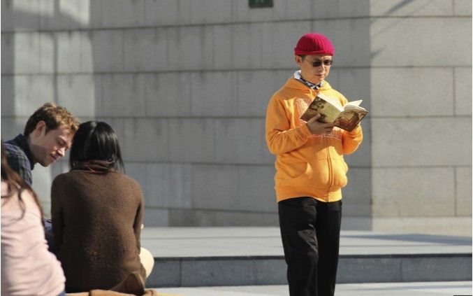 Le milliardaire Xiao Jianhua en train de lire sous l’International Finance Center à Hong Kong, en décembre 2013. (AP Photo/Next Magazine)