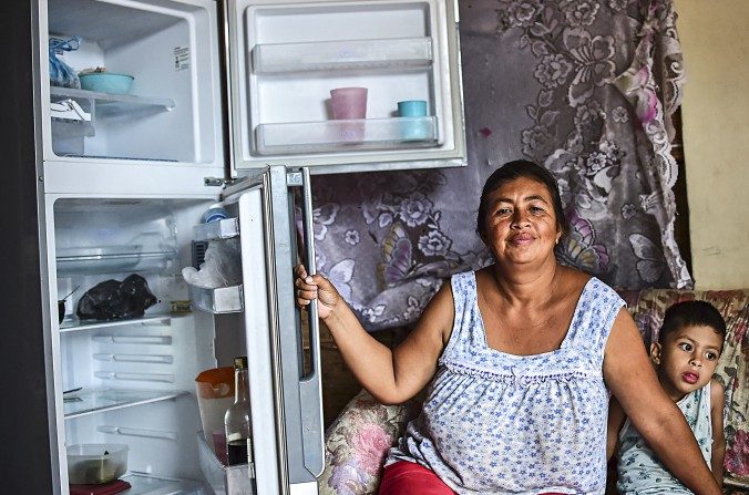 Une femme montre son réfrigérateur vide à Caracas, Venezuela, le 2 juin 2016. De nombreux Vénézuéliens n’arrivent pas à acheter assez de nourriture. (RONALDO SCHEMIDT / AFP / Getty Images)