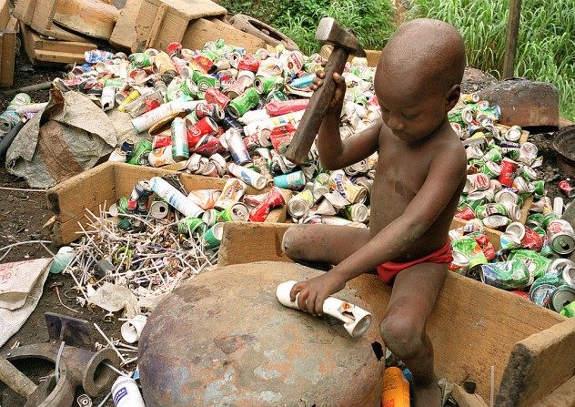 Alpha, âgé de 4 ans, frappe une bombe aérosol avec un marteau pour récupérer l’aluminium qu’elle contient le 9 octobre 1999, à Abidjan, en Côte d’Ivoire. (Jean-Philippe Ksiazek/AFP/Getty Images)