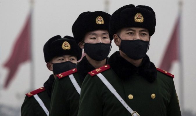 La police paramilitaire chinoise avec des masques antipollution sur la place Tiananmen, le 9 décembre 2015, à Pékin.  (Kevin Frayer / Getty Images)