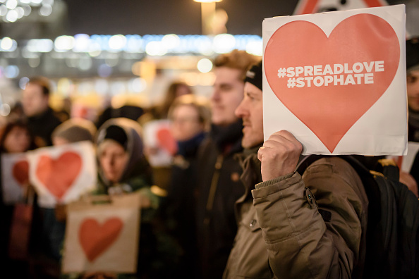 Un manifestant tient un panneau avec un coeur rouge accompagné des hashtags 'spreadlove' et 'stophate' près du lieu de l'attentat terroriste sur un marché de Noël à Berlin le 21 décembre 2016. (CLEMENS BILAN/AFP/Getty Images)