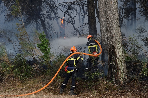 Des pompiers essaient d’éteindre un feu de forêt à Saint-Cannat, près d’Aix-en-Provence, dans les Bouches-du-Rhône, le 15 juillet 2017. (FRANCK PENNANT/AFP/Getty Images)