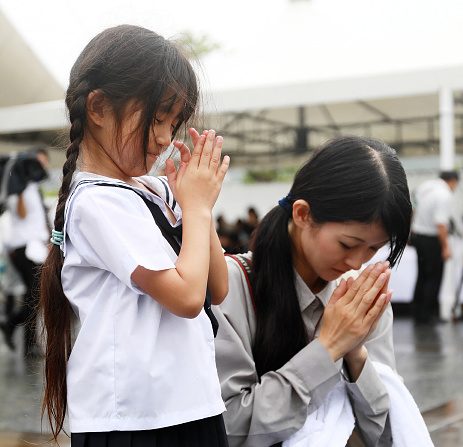 Une mère et sa fille prient pour les victimes du bombardement nucléaire de Nagasaki au Parc du mémorial de la Paix à Nagasaki le 9 août 2017. (STR/AFP/Getty Images)