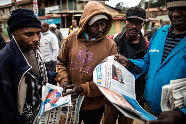 Des Kényans lisent les journaux, attendant les résultats des élections présidentielles opposant le président sortant Uhuru Kenyatta, largement en tête, à Raila Odinga. Il leur est demander de faire "preuve de patience". (MARCO LONGARI/AFP/Getty Images)