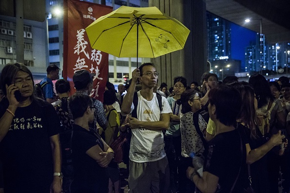 Face au  tribunal correctionnel de Lai Chi Kok à Hong Kong le 18 août 2017, un manifestant tient un parapluie jaune, symbole du mouvement prodémocratique, pour protester contre l'emprisonnement de Joshua Wong, Nathan Law and Alex Chow, les leaders du mouvement des parapluies. (ISAAC LAWRENCE/AFP/Getty Images)