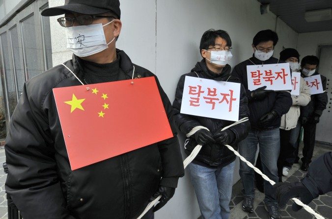 Le 21 février 2012, devant l'ambassade de Chine à Séoul, les militants des droits de l’homme imitent les policiers chinois et les réfugiés nord-coréens lors d'un rassemblement pour l’arrêt du renvoi en Corée du Nord des réfugiés arrêtés en Chine. Le régime chinois a intensifié la répression contre les Nord-Coréens qui essayent de fuir le régime de Kim. (JUNG YEON-JE/AFP/Getty Images)
