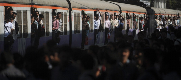 Un train de voyageurs surpeuplé s'approche d'une plate-forme de station à Mumbai.   
Le chemin de fer, le plus grand employeur du pays avec quelque 1,4 million de personnes sur sa masse salariale.    
(PUNIT PARANJPE/AFP/Getty Images)

